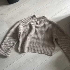 Stickad tröja - En beige stickad tröja. Säljer på grund av att jag inte använder den