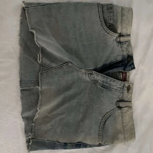 Unik Jeans kjol - Snygg blå jeanskjol med skiftande färg fram och bak vilket ger en cool och utstickande detalj. Säljer då de är för små. Snygga fickor