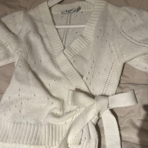 Söt vit kortärmad kofta med knyte på sidan. - Fin kortärmad kofta med inga defekter och inte använd många gånger, alltså fint skick! Köparen står för frakten!