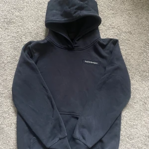 Mörkblå hoodie från Peak Performance - Säljer en stilren mörkblå hoodie från Peak Performance. Den har en klassisk design med en stor huva och en praktisk magficka. Perfekt för en avslappnad look.