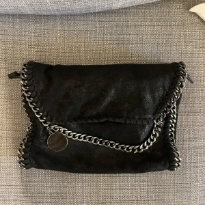 Stella McCartney liknande väska - Svart skimrig Stella McCartney liknande väska med leopardmönster inuti. Använd men bra skick!