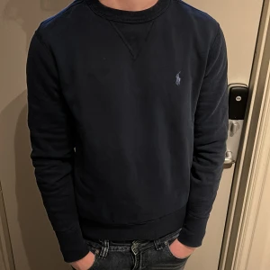 Ralph lauren tröja - Säljer en stilren mörkblå tröja från Ralph Lauren. Personen på bilden är ca 180 lång och väger 70 kg. Tveka inte på att kontakta mig vid vid minsta fundering eller eventuella frågor🙌