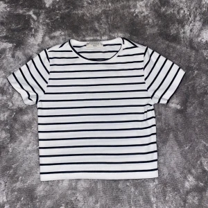 Randig t-shirt från Chiquelle - Säljer en stilren vit och svart randig t-shirt från Chiquelle i storlek medium. Den har korta ärmar och en klassisk rund halsringning. Aldrig använd🫶🏻