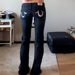 Unika True Religon jeans - Jätte snygga och unika True religon jeans i väldigt bra skick. Midjemåttet tvärsöver är 35 cm och innerbenslängden är 89 cm. Jeansen passar någon som har storlek XXS-XS dock är dom långa i benen så passar någon som är lång. Jag på bilden är 168 cm lång