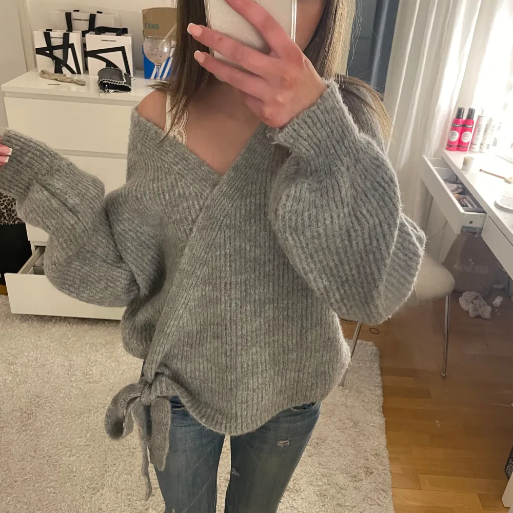Säljer en mysig grå omlottstickad tröja med knytning framtill. Den är använd fåtal gånger och är i toppskick! Från only i storlek xs men skulle mer säga att det är en S/M. Neuletakit & Villapaidat.