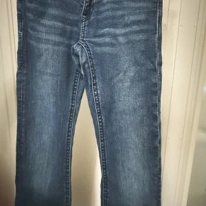 Blå jeans med fickdetaljer - Snygga blå jeans med coola fickdetaljer och kontrastsömmar. De har en klassisk femficksdesign och en bekväm passform. Perfekta för en avslappnad stil. Har använt bara en gång är helt nya och är i bra skick. 