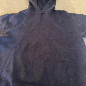 Mörkblå stickad hoodie från Zara - Säljer en mörkblå hoodie från Zara i storlek 152. Perfekt för kyliga dagar med sin mjuka och bekväma design. Den har en klassisk huva och är tillverkad i ett material som känns skönt mot huden. Passar bra till både jeans och mjukisbyxor.