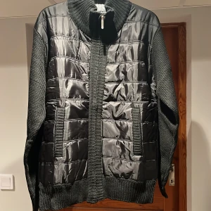 Svart cardigan jacka - Snygg svart jacka med quiltade paneler och stickade ärmar. Jackan har en dragkedja framtill och ribbade muddar. Perfekt för en stilren look och perfekt till våren. Har bara en defekt som syns på fjärde bilden. Skulle säga den passar någon som är 170. Det är bara att fråga om ni undrar något eller vill ha flera bilder ☺️(priset är inte hugget i sten)