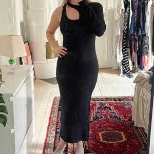 Svart oneshoulder klänning - Snygg svart oneshoulder klänning med en cool asymmetrisk design. Klänningen har en slits på sidan och är ribbad för en stilren look. Perfekt för en kväll ute eller en speciell tillställning. 🌸