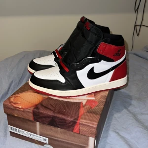 Jordan 1 Retro High OG ’Black Toe Reimagined’ - Helt nytt par, inte ens provade. Ikoniskt par Michael Jordan på en av dem coolaste boxarna Signaturen på insidan av skorna (visas på bild) Två typer av skosnören (Röda och Svarta) Jättebra läder. Coolt emballage (får inte plats med flera bilder, kan skicka privat)