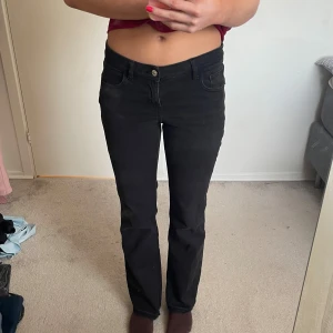 Svarta jeansbyxor - Snygga svarta jeansbyxor med en klassisk design. De har en knapp och dragkedja framtill samt fickor både fram och bak. Byxorna har en rak passform som ger en stilren look.