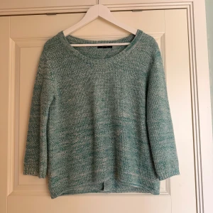 Grön stickad tröja - Säljer en mysig grön stickad tröja med trekvartsärmar. Perfekt för kyligare dagar och har en avslappnad passform. Tröjan har en enkel design som gör den lätt att matcha med olika outfits.