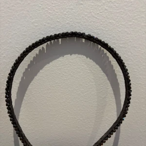 Svart diadem med glittriga stenar - Elegant svart diadem dekorerat med glittriga stenar som ger en lyxig känsla. Perfekt för att addera lite extra glamour till din look. Passar bra till både uppsatt och utsläppt hår.