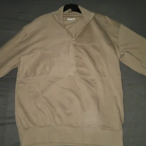 Beige tröja med dragkedja från Kappahl - Säljer en beige tröja från Kappahl med dragkedja vid halsen. Tröjan är tillverkad i bomull och har långa ärmar. Perfekt för en avslappnad stil. Inte andvänd