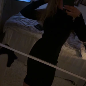 Svart långärmad klänning - Snygg svart klänning med lång ärm och figurnära passform. Perfekt för en stilren look. Klänningen har en enkel design som gör den lätt att matcha med olika accessoarer.