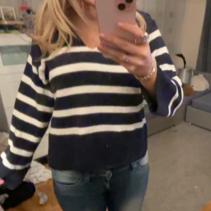 Randig tröja i blått och vitt - Stickad randig tröja med slits på sidorna och en ”krage” Från Gina tricot, sällan använd storlek M