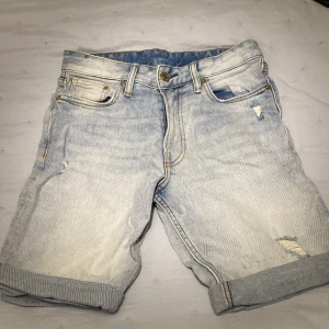 Ljusa jeansshorts från &Denim - Snygga ljusa jeansshorts från &Denim med en slim fit passform. De har en klassisk femficksdesign och slitna detaljer för en trendig look. Perfekta för varma dagar!