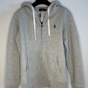 Polo zip - Säljer en stilren grå hoodie från Polo Ralph Lauren. Storlek M, sitter bäst på dig mellan 173-176 skulle jag bedöma. Helt oanvänd, skriv gärna vid frågo!!