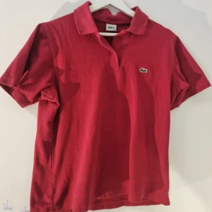 Lacoste pike - Snygg röd pikétröja från Lacoste med krage och korta ärmar storlek storlek:S  ingår ej i ralph lauren dealen