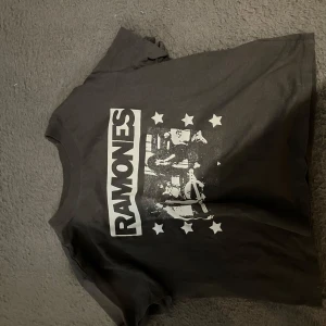 Svart Ramones t-shirt från H&M - Säljer en svart t-shirt från H&M med Ramones-tryck i vitt. T-shirten har korta ärmar och en klassisk rund halsringning. Stl M, glömt bort vad jag köpte för men säljer för 75, men pris kan diskuteras!💗