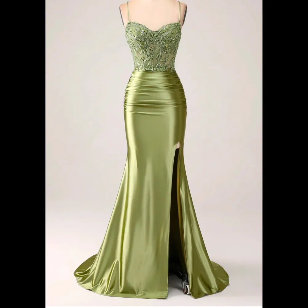 Jag säljer nu min vackra balklänning. Elegant grön bal klänning i satin med en vacker slits framtill och snörning i ryggen. Överdelen är dekorerad med paljetter som ger en glittrig effekt. Perfekt för bal💚. Pris kan diskuteras!. Mekot.