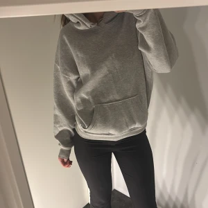 Grå hoodie - Säljer en bekväm och stilren grå hoodie. Perfekt för en avslappnad look. Den har långa ärmar och en klassisk huva.