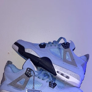 Nike Air Jordans i ljusblått - Snygga Nike Air Jordans i ljusblått med svarta och vita detaljer. Skorna har jag aldrig använt, utan de har bara stått i rummet mer som prydnad.