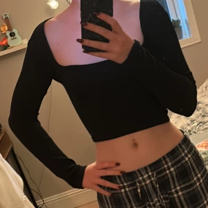 Svart croppad topp från Zara - Säljer en svart croppad topp från Zara med långa ärmar. Toppen har en stilren design och är perfekt för en trendig look. Den är tillverkad i ett mjukt material som ger en bekväm passform.