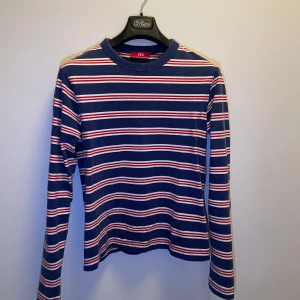 Randig tröja från Zara - Säljer en snygg randig tröja från Zara i blått, vitt och rött. Tröjan har långa ärmar och en klassisk rund halsringning. Perfekt för en avslappnad stil.