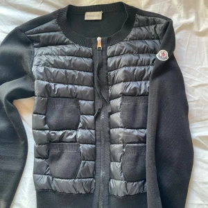 Svart jacka från Moncler - Snygg svart jacka från Moncler med quiltade detaljer och dragkedja framtill. Jackan har långa ärmar och två praktiska fickor på framsidan. Perfekt för kyligare dagar. Storlek xs/s 
