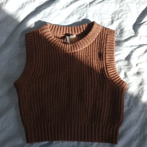 Brun stickad väst från Divided - Säljer en snygg brun stickad väst från Divided. Västen har en ribbad design och är ärmlös, perfekt för lager-på-lager-stil. Den har en rund halsringning och är i storlek XS. Har knappt använt den så den är som ny❤️