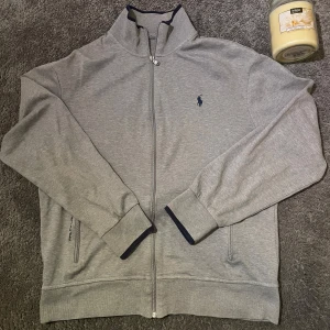 Grå zip-tröja Ralph Lauren herr - Snygg grå zip-tröja från Ralph Lauren. Perfekt för en stilren och avslappnad look. Storlek M! Jag är 182 och där omkring passar den! Jättebra skick! Skriv för intresse!