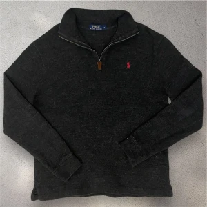 Mörkgrå tröja från Ralph Lauren - Snygg mörkgrå Ralph lauren quarter zip tröja. Riktigt fint skick utan deffekter. Modellen är 180 cm lång och väger 65 kilo