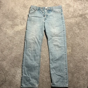 Ljusblå jeans Studio total  - Snygga ljusblå jeans med knappar framtill. De har en klassisk straight passform och är perfekta för en avslappnad stil. Passar bra till både sneakers och kängor. Köpta på junkyard.