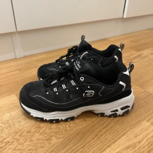 Svarta sneakers från Skechers - Säljer ett par svarta Skechers sneakers med vit sula och snörning. Dom är supersköna och använda 1 gång. Säljer för att dom inte kommer till användning. Nypris 1299 kr. Säljer för 500