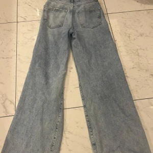 Ljusa jeans med vida ben från Perfect Jeans - Snygga ljusa jeans med vida ben och slitna detaljer på knäna från Perfect Jeans. Perfekta för en avslappnad stil. De har en klassisk femficksdesign och är tillverkade i ett bekvämt denimtyg.