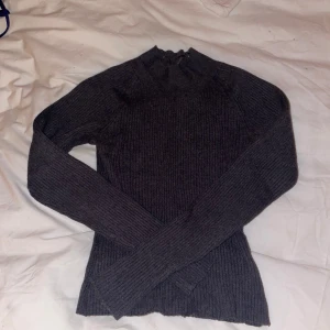 Grå ribbad tröja - Säljer en stilren grå ribbad tröja med långärmad design. Perfekt för kyligare dagar med sin mjuka och bekväma passform. Passar bra till både jeans och kjol.