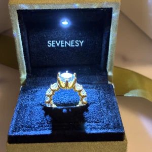 Deluxe ring från Sevenesy - Elegant guldfärgad ring från Sevenesy, dekorerad med gnistrande stenar runt hela bandet och en större sten i mitten. Perfekt för att ge en lyxig touch till din stil. STORLEK 52 (priset kan diskuteras vid en smidig affär)