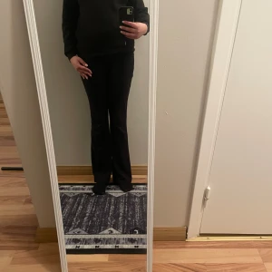 Svart sweatshirt med tryck - Säljer en svart sweatshirt med ett coolt tryck på ryggen som har texten 'BE TRUE OF' i rosa och grått. Tröjan har långa ärmar och en avslappnad passform. Perfekt för en casual look!