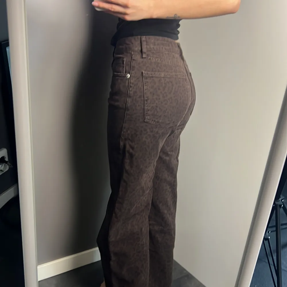 Snygga bruna jeans med leopardmönster. Byxorna har en hög midja och är raka i passformen.. Farkut & Housut.