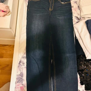 Mörkblå jeansbyxor - Snygga mörkblå jeansbyxor med kontrasterande sömmar. Klassisk design med fem fickor och dragkedja. Perfekta för en avslappnad stil.