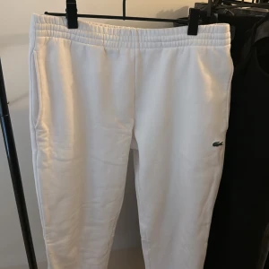 Lacoste byxor - Vita byxor från Lacoste. Byxorna är i storlek L och är slim fit. Byxorna är riktigt bekväma och fräscha.