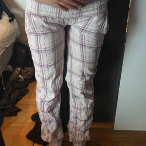 Rutig byxa i vitt och lila - Snygga och bekväma byxor med rutig design i vitt och lila. Byxorna har en avslappnad passform och är perfekta för en dag hemma. De har en elastisk midja låg midja. skriv om pris mått osv🥰