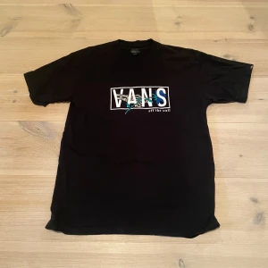 Svart Vans t-shirt  - Säljer en svart Vans t-shirt med logga i vitt och blått på bröstet. Skriv för frågor och mått osv