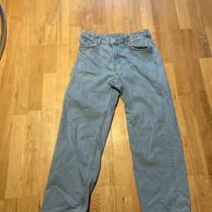 Blå jeansbyxor - Säljer ett par klassiska blå jeansbyxor med normal passform. Byxorna har en traditionell femficksdesign och stängs med knapp och dragkedja. Perfekta för en avslappnad stil.