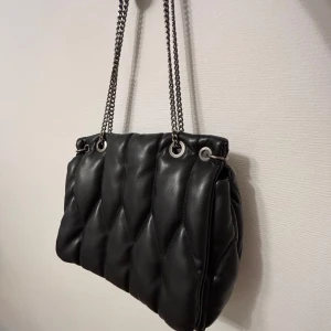 Väska Zara - Snygg svart axelväska i quiltat mönster med kedjeaxelremmar. Från Zara