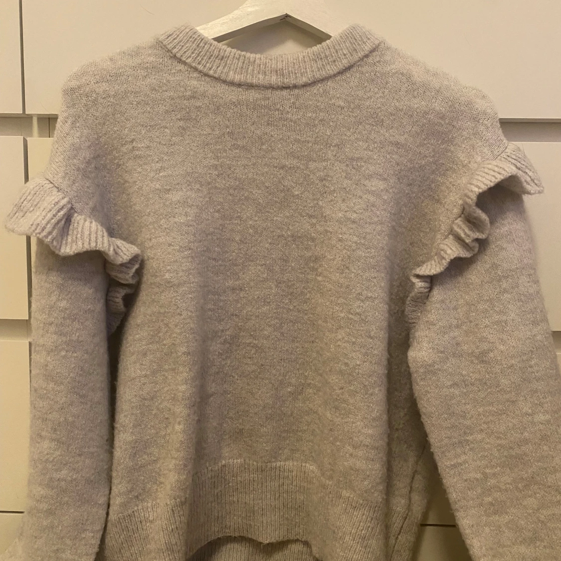 Grå stickad tröja med volangdetaljer