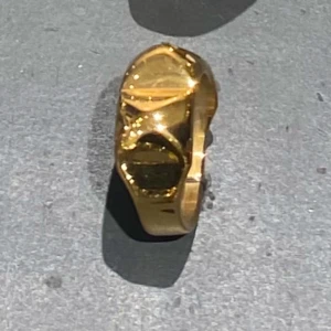 Guldfärgad ring - Elegant guldfärgad ring med en unik design. Ringen har en blank yta och geometriska former som ger den ett modernt utseende. Perfekt för att lägga till en touch av stil till din outfit.