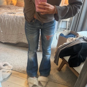 Blå bootcut jeans low waist  - Snygga blå bootcut jeans med slitningar och low waist. Från levis. W 27 L30