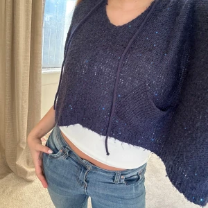 Marinblå paljetthoodie - Säljer denna superfina trendiga stickade hoodie med paljetter och ficka. Så perfekt till våren! Storlek L men passar mindre om man gillar oversized!